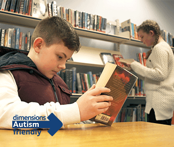 autism friendly libraries campaign image - child reading book in library