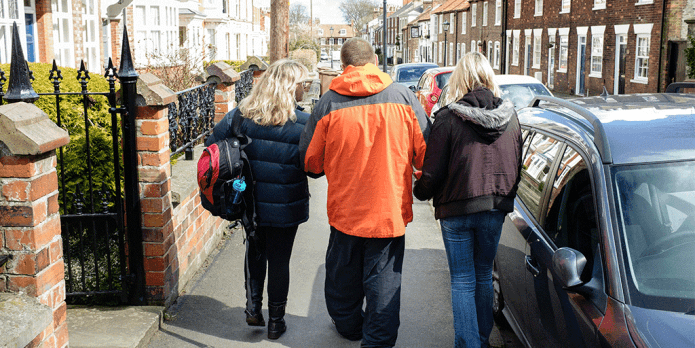 man walking with support workers